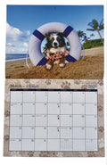 March 2026 calendar page from Paws in Paradise 2026 Calendar featuring Mini Australian Shepherd with flower lei posed inside life preserver on Hawaiian beach

