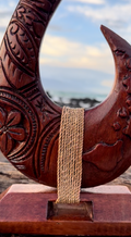 Carved wooden hook with a rope against a scenic background