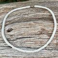 White shell necklace on a wooden surface